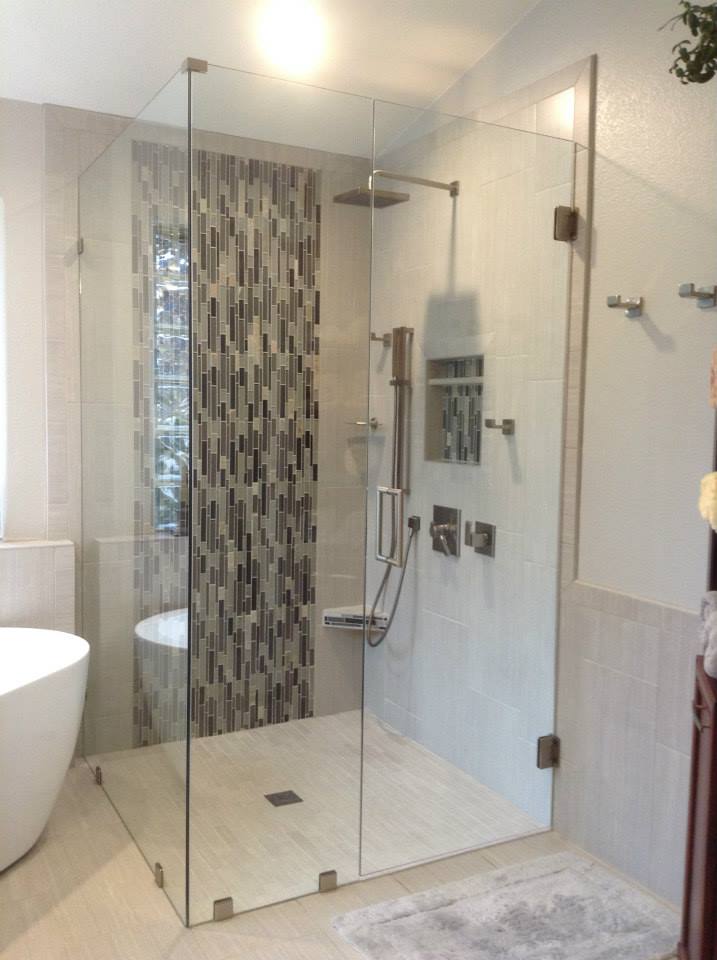 Frameless walk-in shower with mosaic tile accent wall